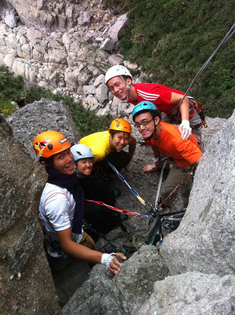 The party of 4 + 1(photographer) hanging out on the ledge of Via Del Drago